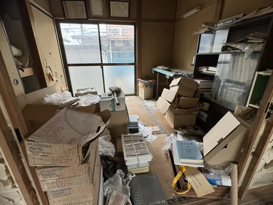不用品回収のビフォー：段ボールや書類が積み重なった和室（栃木県内）